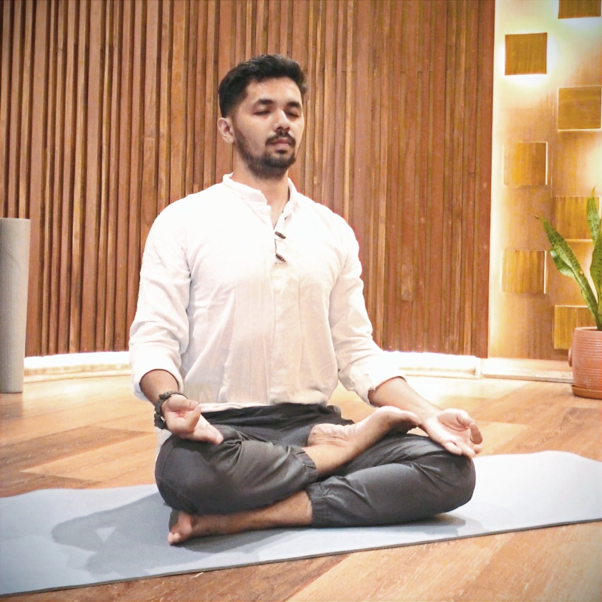 The founder of GoYoga seated in padmasana, meditating on a mat in the studio
